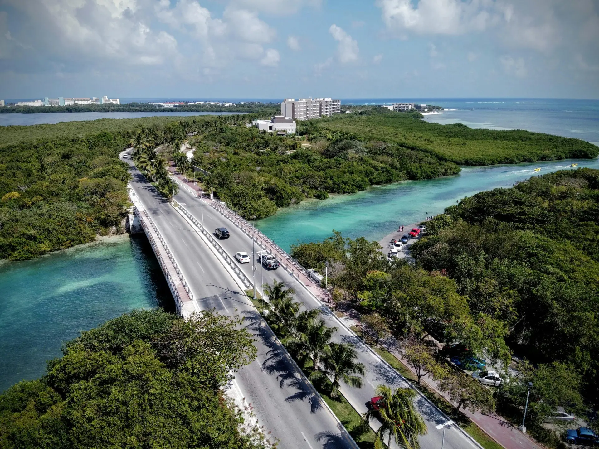 Stunning aerial view of a road bridge crossing over turquoise waters near Cancun, Mexico.